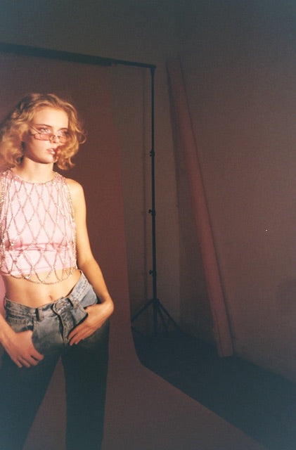Body Chain Top in Silver worn over a pink halter top. Body fashion accessory.